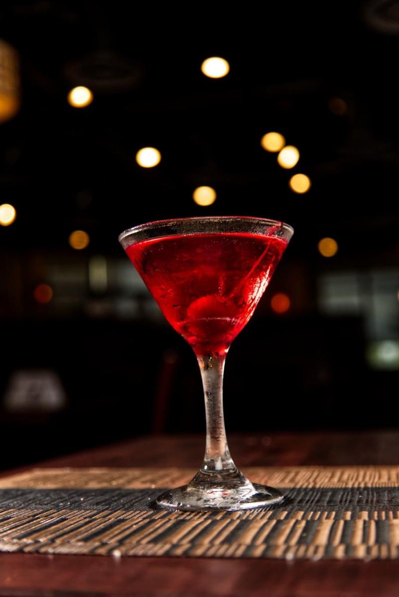 Pomegranate peach martini glowing against the bar lights